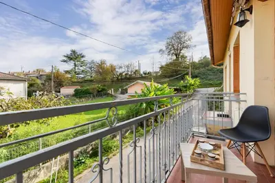 a balcony with a chair and a view of a yard at L'Écrin de Pamiers - Appt climatisé pour 6 in Pamiers
