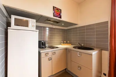 a small kitchen with a sink and a microwave at L'Écrin de Pamiers - Appt climatisé pour 6 in Pamiers