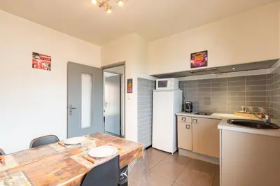 a kitchen with a wooden table and a counter top at L'Écrin de Pamiers - Appt climatisé pour 6 in Pamiers