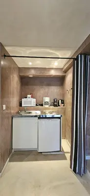 a kitchen with a sink and a microwave at Le Clos Saint Jean, vue Cité, piscine et parking in Carcassonne
