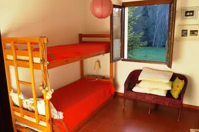 a bedroom with two bunk beds and a window at Maison 90m2 avec grand parc au bord de la rivière in Montredon-Labessonnié