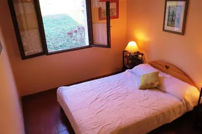 a bedroom with a white bed with two windows at Maison 90m2 avec grand parc au bord de la rivière in Montredon-Labessonnié