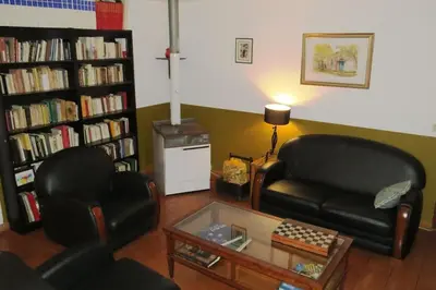 a living room with two chairs and a couch and a table at Maison 90m2 avec grand parc au bord de la rivière in Montredon-Labessonnié