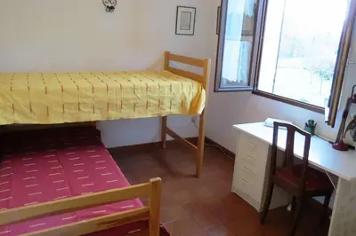 a bedroom with a bed and a desk and a chair at Maison 90m2 avec grand parc au bord de la rivière in Montredon-Labessonnié