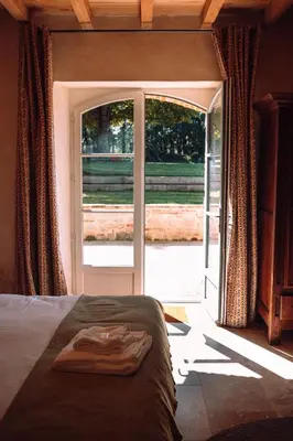 a bedroom with a bed in front of a sliding glass door at Chambre tout confort à l'Héritier - au coeur du Tarn in Marzens