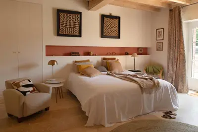 a bedroom with a large bed and a chair at Chambre tout confort à l'Héritier - au coeur du Tarn in Marzens