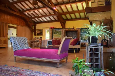 a living room with a purple couch and chairs at Chambres d'Hôtes L'Orée des Bois in Lacrouzette