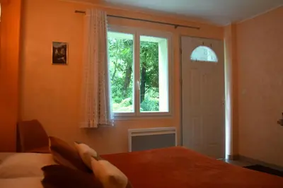 a bedroom with a bed and a window at Chambres d'Hôtes L'Orée des Bois in Lacrouzette