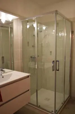 a glass shower in a bathroom with a sink at Chambres d'Hôtes L'Orée des Bois in Lacrouzette