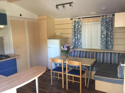 a small kitchen and dining room with a table and chairs at Mobilhome Ferme équestre La Mouillère in Chalabre