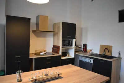 a kitchen with a wooden table and a counter top at La Vue de Manuel in Carcassonne
