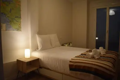 a bedroom with a bed with a lamp on a table at La Vue de Manuel in Carcassonne