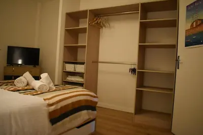 a bedroom with a bed and a tv and shelves at La Vue de Manuel in Carcassonne