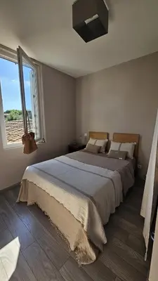 a bedroom with a large bed and a window at Appartement PETIT SAINT GIMER in Carcassonne