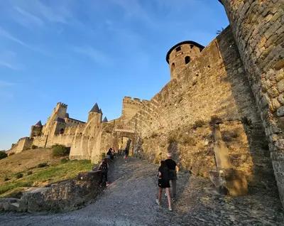 a group of people walking around a castle at Appartement PETIT SAINT GIMER in Carcassonne