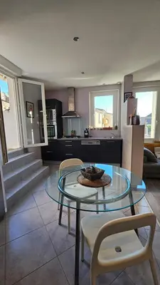 a living room with a glass table and chairs at Appartement PETIT SAINT GIMER in Carcassonne