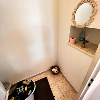 a bathroom with a toilet and a mirror at Maison de vacances spa in Narbonne