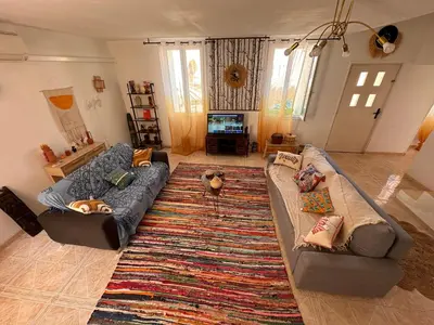 a living room with two couches and a rug at Maison de vacances spa in Narbonne