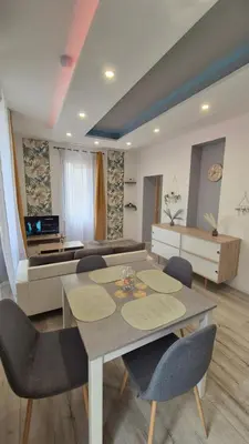 a living room with a table and chairs and a couch at l'instant cosy in Tuchan