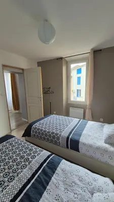 a bedroom with two beds and a window at l'instant cosy in Tuchan