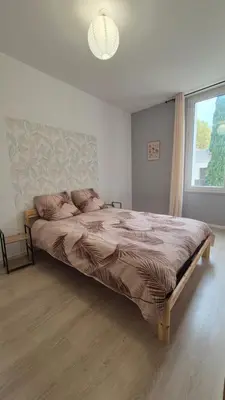 a large bed in a bedroom with a window at l'instant cosy in Tuchan