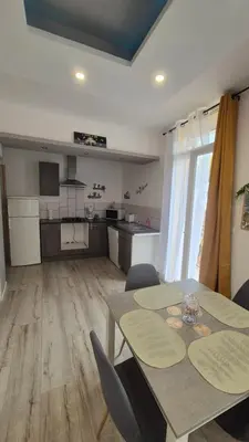 a kitchen and dining room with a table and chairs at l'instant cosy in Tuchan