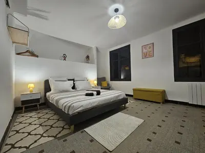 a bedroom with a large bed and two windows at Vue Cité Médiévale Castel View in Carcassonne