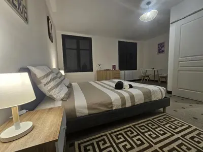 a bedroom with a bed with a lamp and a table at Vue Cité Médiévale Castel View in Carcassonne
