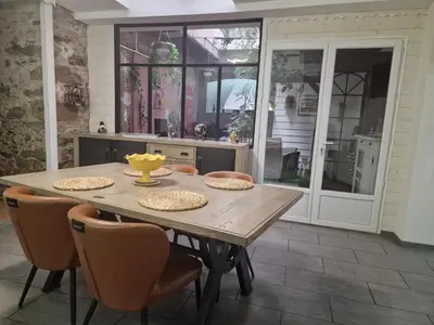 a living room with a couch and a painting of birds at L'escapade colorée anciennement La Vieille Forge in Rieux-Minervois