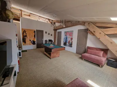 a living room with a pool table and a couch at L'escapade colorée anciennement La Vieille Forge in Rieux-Minervois