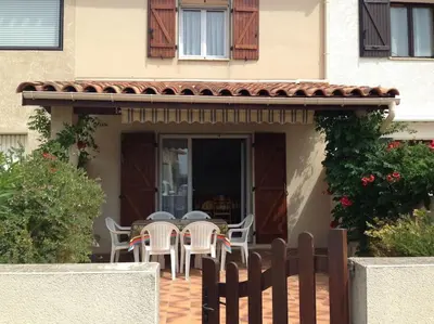 a patio with chairs and a table in front of a house at Maison 6 personnes plage à 5min in Port-la-Nouvelle