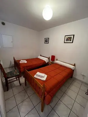 a bedroom with two beds and a chair at Maison 6 personnes plage à 5min in Port-la-Nouvelle