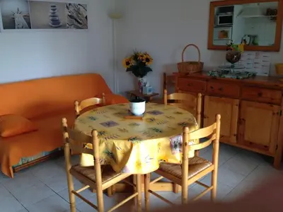 a kitchen with a table and chairs and a bed at Maison 6 personnes plage à 5min in Port-la-Nouvelle