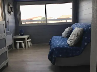 a living room with a couch and a window at Maison 6 personnes plage à 5min in Port-la-Nouvelle