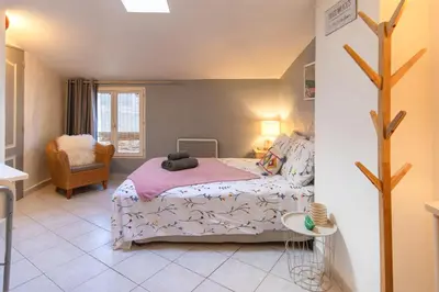 a bedroom with a bed and a chair at Le Segarius superbe maison médiévale Internet WiFi gratuit Climatisation Jardin in Puisserguier