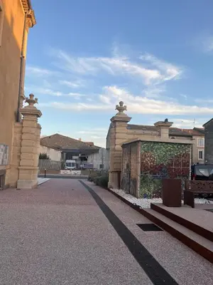 a building with a gate in the middle of a street at Le Segarius superbe maison médiévale Internet WiFi gratuit Climatisation Jardin in Puisserguier