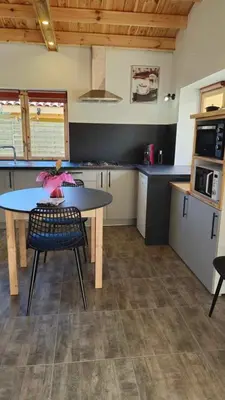 a kitchen with a table and chairs in a kitchen at Chalet détente in Montaut