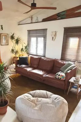 a living room with a brown leather couch and chairs at Chalet - Beach House in Gruissan