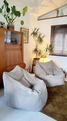 a living room with a white couch and a chair at Chalet - Beach House in Gruissan