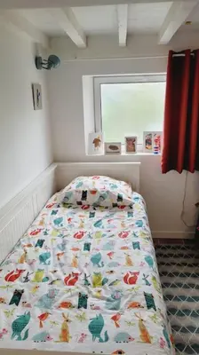 a bedroom with a bed with a comforter and a window at Chalet - Beach House in Gruissan