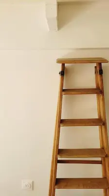 a wooden ladder in the corner of a room at Chalet - Beach House in Gruissan
