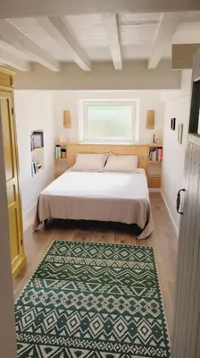 a bedroom with a bed with a green and white rug at Chalet - Beach House in Gruissan