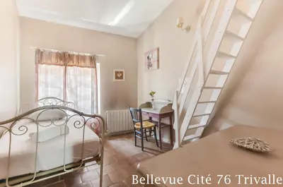 a bedroom with a staircase and a table and a desk at Les Bellevue Cité Trivalle 