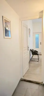 a hallway with a door and a chair in a room at Tour Ouest - T2 entre Cité Médiévale et Bastide in Carcassonne
