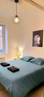 a bedroom with a large bed with two towels on it at Tour Ouest - T2 entre Cité Médiévale et Bastide in Carcassonne