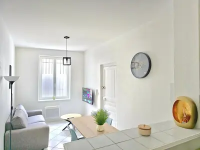 a white living room with a table and a couch at Tour Est - T2 entre Cité Médiévale et Bastide in Carcassonne