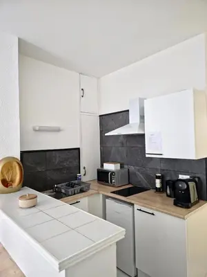 a kitchen with white cabinets and a white counter top at Tour Est - T2 entre Cité Médiévale et Bastide in Carcassonne