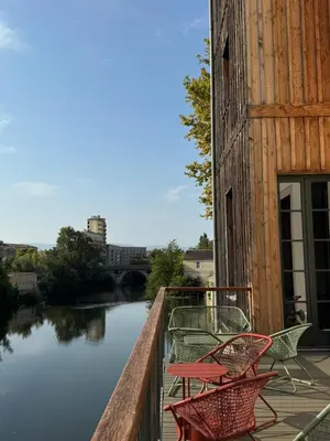 a group of chairs sitting on a balcony next to a river at Grand Hotel de Castres in Castres