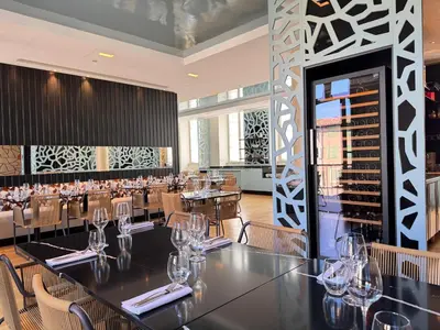 a restaurant with tables and chairs and wine bottles at Grand Hotel de Castres in Castres