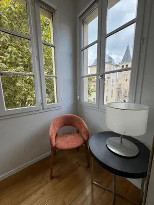 a room with a chair and a table and windows at Grand Hotel de Castres in Castres